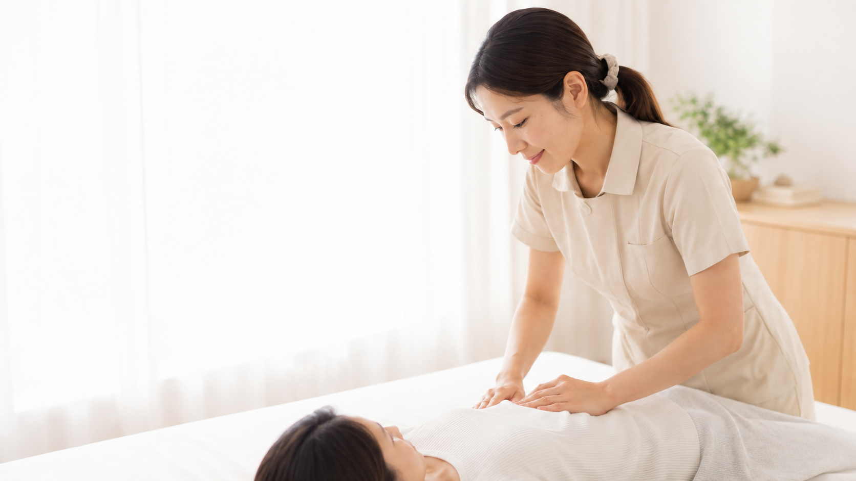 自宅で産後の女性へ施術を行う女性セラピスト